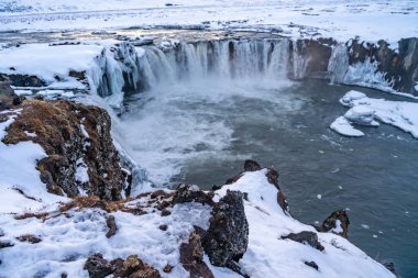 Kışın gün batımında İzlanda 'da donmuş Godafoss şelalesinin manzara ayrıntıları.