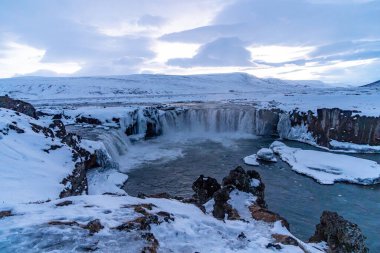 Kışın gün batımında İzlanda 'da donmuş Godafoss şelalesinin manzara ayrıntıları.
