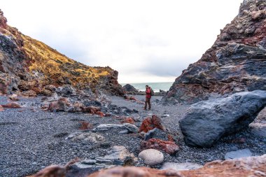 İzlanda 'nın Snaefellsnes yarımadasındaki Djupalonssandur plajında bir turist.