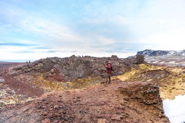 İzlanda, Snaefellsnes Yarımadası 'nda, kışın Saxholl volkan kraterinde sırt çantalı bir yürüyüşçü.