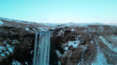 Skogafoss şelalesinin karlı ve kışın İzlanda 'da bol miktarda suyu olan insansız hava görüntüsü.