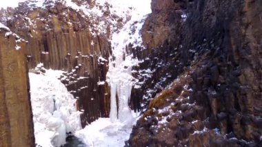 Hengifoss şelalesi soğuk İzlanda kışında donmuştu. Volkanik kayalıkların ayrıntıları.