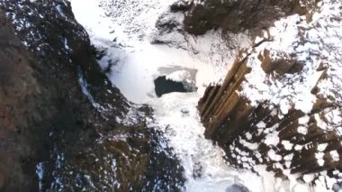 Hengifoss şelalesi soğuk İzlanda kışında donmuştu. Volkanik kayalıkların ayrıntıları.
