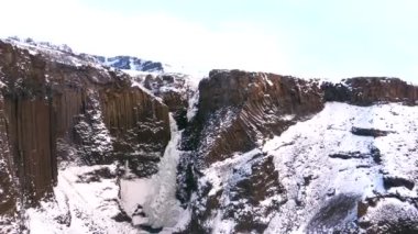 Hengifoss şelalesi soğuk İzlanda kışında donmuştu. Volkanik kayalıkların ayrıntıları.