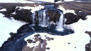 Kışın İzlanda 'daki ünlü Kirkjufell dağına kar yağan şelalenin insansız hava aracı görüntüsü