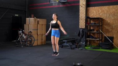 Bir spor salonunda tek başına ip atlayan Çinli bir kadının uzun bir videosu.