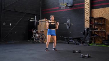 Düşük açılı görüntü. Üç çeyrek boyunda Asyalı bir kadının ağırlık çekmek için düz makine kullandığını gösteren bir fotoğraf.