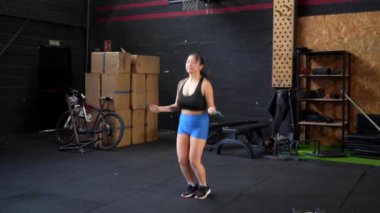 Bir spor salonunda tek başına ip atlayan Çinli bir kadının uzun bir videosu.