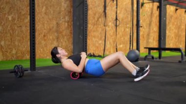 Güçlü bir Çinli genç kadının, spor salonunun halkalarına asılmış kaslarını çalıştırması.