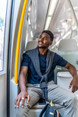 Pencereden bakan mutlu bir Afrikalı girişimcinin dikey fotoğrafı.