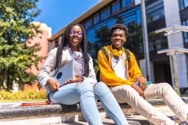 Üniversite kampüsündeki iki havalı Afrikalı Amerikalı öğrencinin düşük açılı portresi.