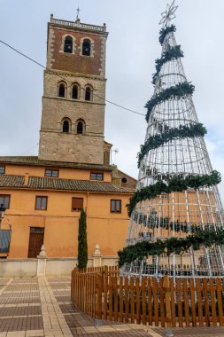 Parish church of San Miguel in Villalon de Campos decorated with a Christmas tree. Valladolid clipart