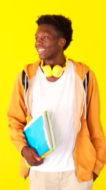 Stüdyo portresi, sarı arka planda, ciddi duran Afrikalı bir öğrencinin