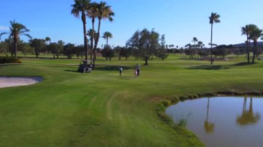 Üzerinde insanların golf oynadığı bir golf sahasının havadan görünüşü.