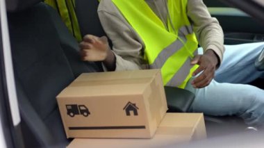 Paketlerle dolu bir arabanın içindeki Afrikalı genç adam.