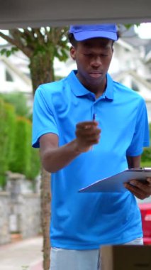 Afrikalı teslimatçı bir minibüsün içinde teslimat yapmak için paketlerin envanterini çıkarıyor.