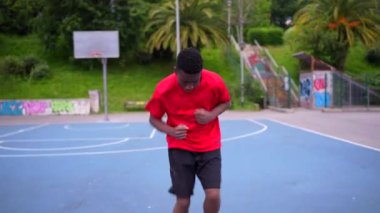 Dışarıda basketbol oynamadan önce lastik elastik bant kullanan Afrikalı bir çocuk.