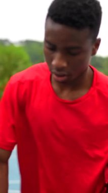 Bir top atmak için zıplayan Afrikalı bir erkek basketbolcunun dikey videosu.