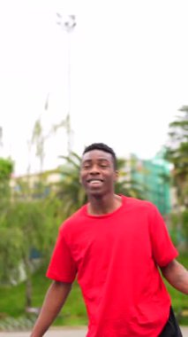 Açık hava basketbol sahasında ip atlayan Afrikalı bir gencin dikey videosu.