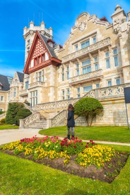 Santander şehrindeki çiçeklerin yanındaki Magdalena Sarayı 'nı ziyaret eden bir kadın.