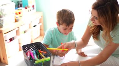 Mutlu ve şefkatli bir anne ve okul çocuğunun evde boyama sahnesi