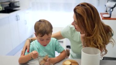 Üç kişilik mutlu bir aile okuldan önce mutfakta kahvaltı ediyor.