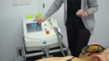 Güzellik kliniğinde yatan kadın modern lazer teknolojisiyle saç temizleme tedavisine hazır.