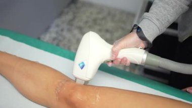 Saç makinesini lazerle söken bir kadının güzellik tedavisinde çekilmiş videosu.