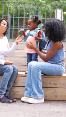 Anne ve büyükanne okuldan aldıkları zaman bir kıza oyun oynuyorlar.