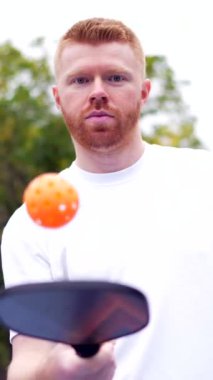 Alçak açı portresi, açık hava mahkemesinde top oynayan enerjik, beyaz bir adamın hareketi.