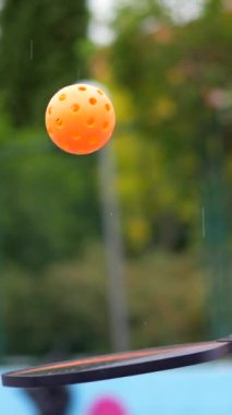 Beyaz tenli bir gencin şehir merkezindeki bir sahada top oynarken düşük açılı portresi.