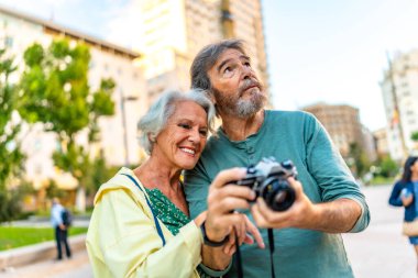 Üst düzey modern Kafkasyalı çift bir şehri ziyaret ederken fotoğraf çekiyor.