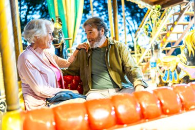Son sınıf modern Kafkasyalı oyuncu çift atlıkarıncada oturuyor ve şehirde birlikte eğleniyorlar.