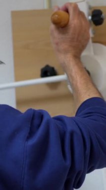 Fizyoterapist, yaşlı bir adamın modern makine ile hareket edebilmesine yardımcı oluyor.