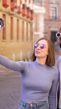 Şehirde cep telefonu ve mikrofonla yayın yapan çok ırklı bir çift.