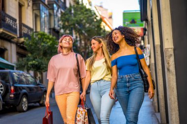 Modern bir şehirde gezen mutlu bayan arkadaşlar.