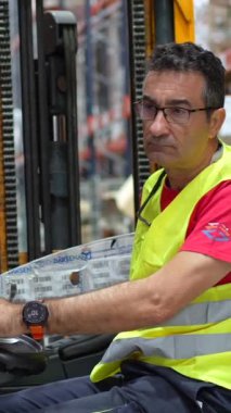 Depoda forklift kullanan olgun bir erkek işçi.