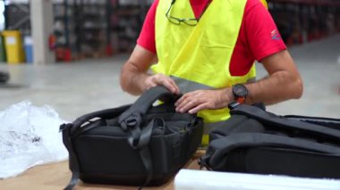 Depodaki ürün barkodlarını okumak için tarayıcı kullanan bir adam.