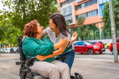 Tekerlekli sandalyede sakat bir kadın ve çok ırklı bir arkadaşı bir araya geldi.