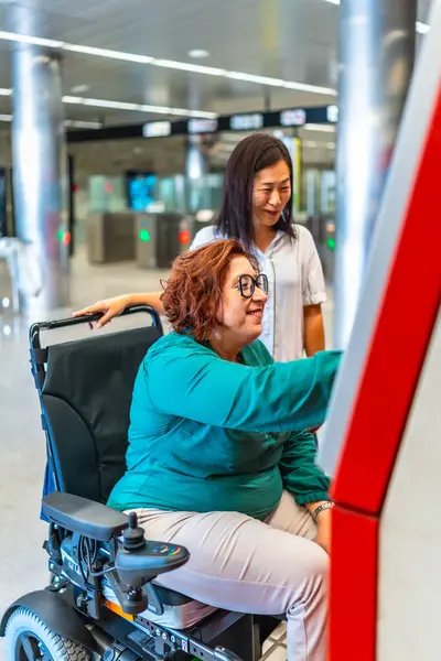 Engelli bir kadın ve arkadaşının metro bileti alırken dikey yan görüntüsü