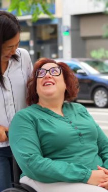 Engelli bir kadın ve arkadaşı güneşli sakin bir günde şehirde geziniyor.