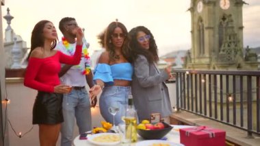 Akşamki çatı partisinde dans eden çok ırklı mutlu arkadaşlar.