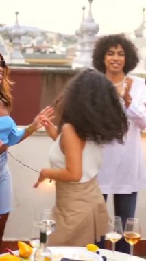 Şehirdeki çatı katı partisinde dans eden heyecanlı çok ırklı arkadaşlar.