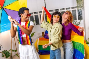 Friends having fun using rainbow umbrella and lgbt flag dancing and celebrating pride at home clipart