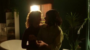 Romantik kadın evde dişlerini fırçalarken lezbiyen ortağına sarılarak sürpriz yapıyor.
