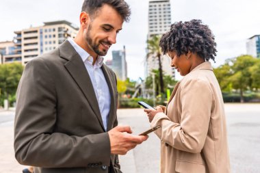 Şehirde cep telefonu kullanan Afrikalı iş kadını ve Kafkas işadamı