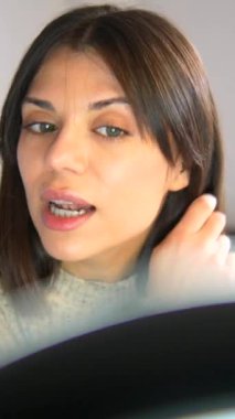 Bir kadın aynanın önünde dikiliyor, süveter giyiyor ve kendine bakıyor. Kadın görünüşünü incelemek için biraz zaman ayırırken, özdüşünüm ve içgörü kavramı