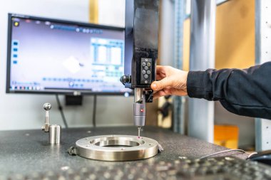 Man working with three-dimensional verification and measuring machine in a cnc innovative factory clipart