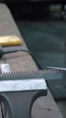 Kafkasyalı yetişkin erkek işçi metal fabrikasında matkap ve manuel aletler kullanarak çalışıyor.