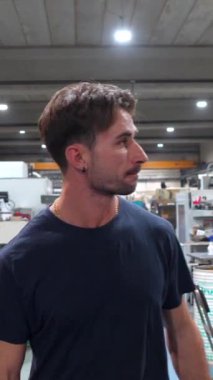 Cnc fabrikasında çalışan genç bir işçinin portresi kameraya bakıyor.